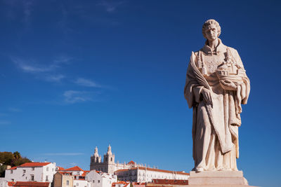 Panorama view - santa luzia viewpoint with a statue, with view to alfama old town - lisbon, portugal