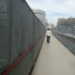 Man standing on bridge against sky