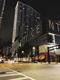 Illuminated city street and buildings at night