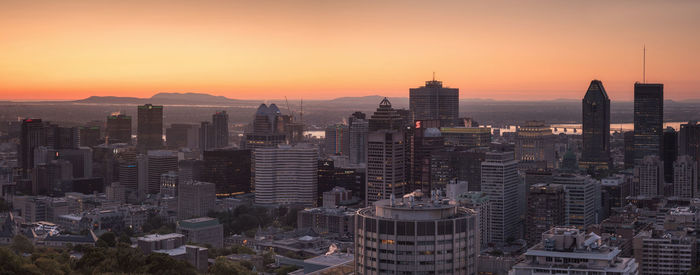 Aerial view of buildings in city during sunset