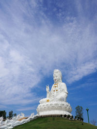 Low angle view of statues against blue sky