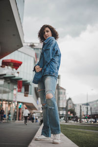 Portrait of woman standing by buildings in city