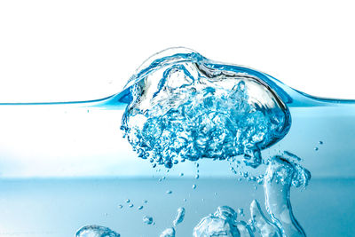 Close-up of splashing water against white background