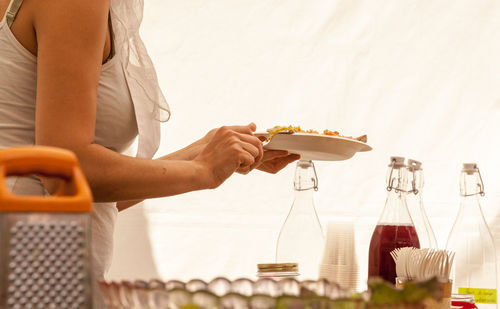 Midsection of woman taking food in buffet