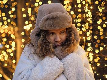 Portrait of woman wearing knit hat at night