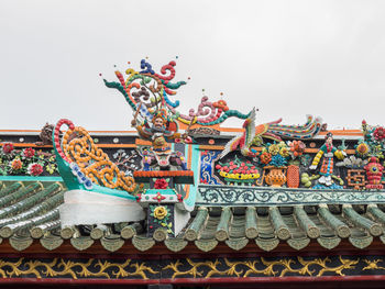 Low angle view of statues on building against sky
