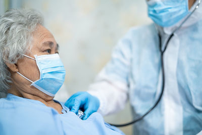 Senior woman wearing mask getting checkup