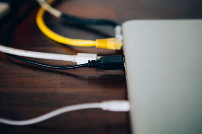 Close-up of computer cables connected to device on table