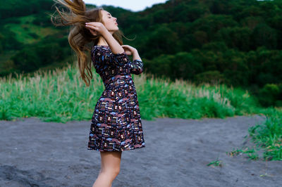 Young woman with tousled hair walking at beach