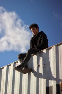 Low angle view of man looking away against sky