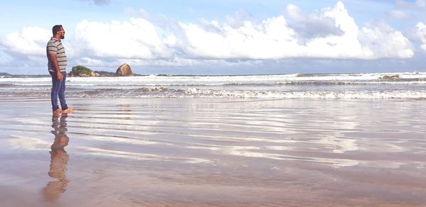 Man standing on beach against sky