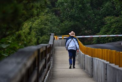 Full length of man walking on footbridge