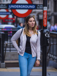 Woman looking away while walking in city