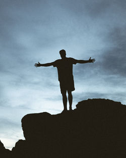 Full length rear view of silhouette man standing against sky