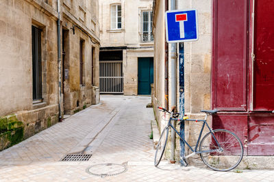 Bicycle and information sign on sidewalk by building