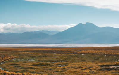 Scenic view of salt flat and mountains against sky