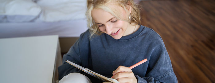 Young woman writing in book