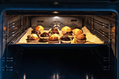 Baking vanilla and chocolate cupcakes in the oven.