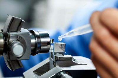 Scientist adding water to glass knife mounted on an ultramicrotome to make specimen sections 