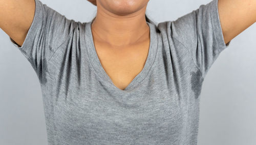 Midsection of teenage girl standing against white background