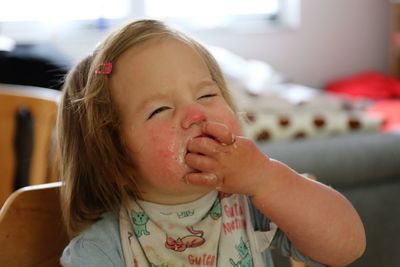 Cute girl eating food at home