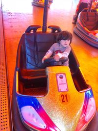 High angle view portrait of girl sitting on swing at playground