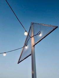 Low angle view of windmill against clear blue sky