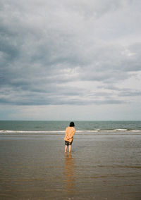 Rear view of man standing on beach