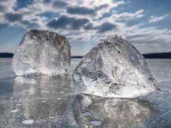 Close-up of ice crystals against sky during winter