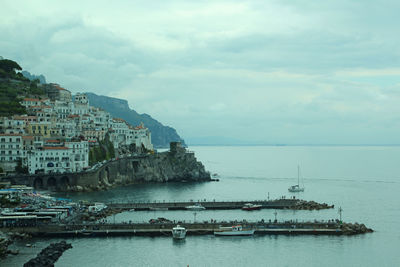 Scenic view of sea by buildings against sky