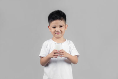 Portrait of boy standing against white background