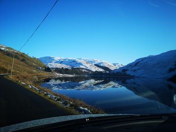 Scenic view of snowcapped mountains against clear blue sky