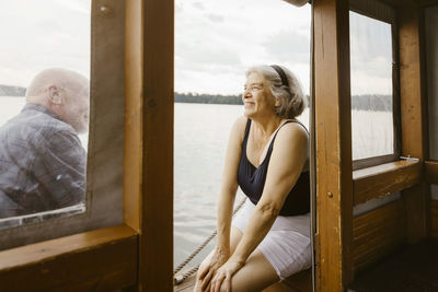 Happy senior woman sitting with man at houseboat