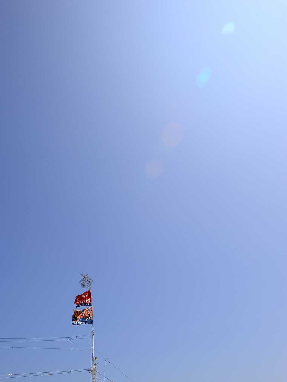 LOW ANGLE VIEW OF FLAGS AGAINST CLEAR SKY