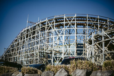 Low angle view of ferris wheel against blue sky