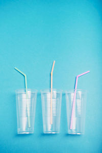 Close-up of plastic glasses against blue background