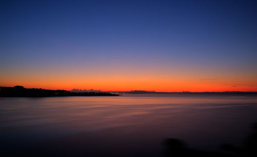 Scenic view of lake against clear sky during sunset