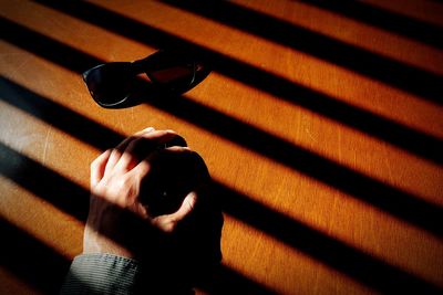 Blinds shadows on table and sunglasses