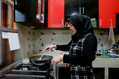 Midsection of woman preparing food in kitchen