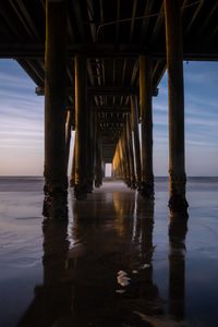 Silhouette of pier over sea against sky