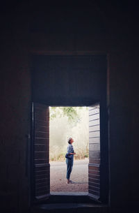 Woman standing by window in building