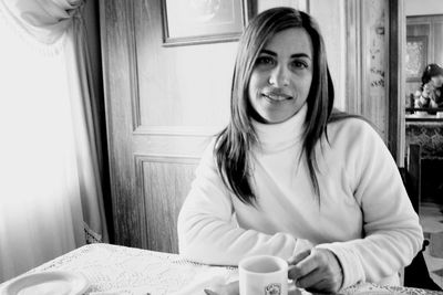 Portrait of a smiling young woman with coffee cup