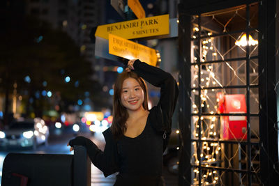 Portrait of young woman standing in city