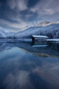 Scenic view of lake by snowcapped mountain against sky