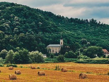 Hay bales on field against mountain