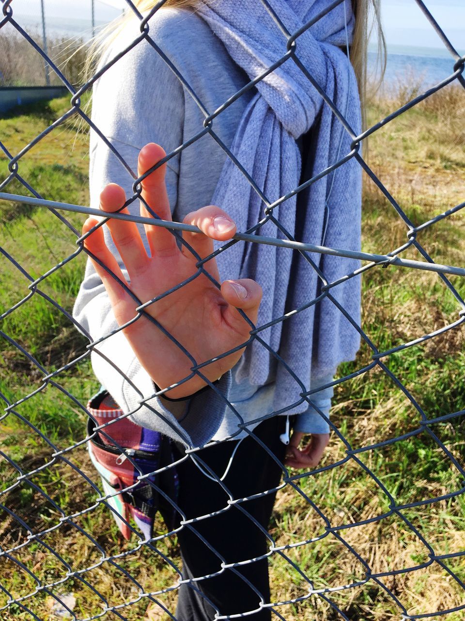 CLOSE-UP OF MAN SEEN THROUGH FENCE