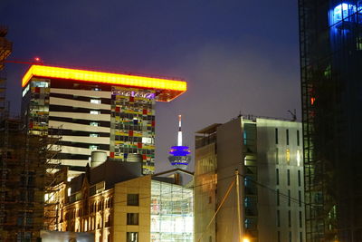 Low angle view of illuminated buildings against sky at night