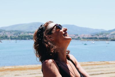 Mid adult woman looking at sea against sky