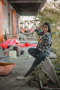 Portrait of a sitting indonesian woman wearing a plaid shirt