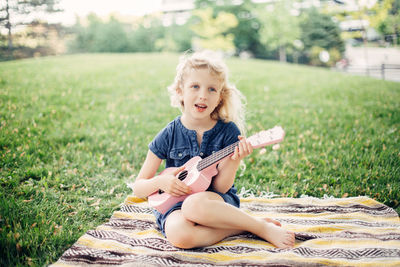 Portrait of cute girl sitting on grass